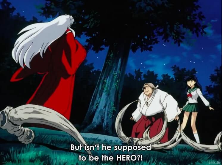 Inuyasha standing off against the village's elder and Kagome. Subtitles read, But isn't he supposed to be the HERO?! End subtitle