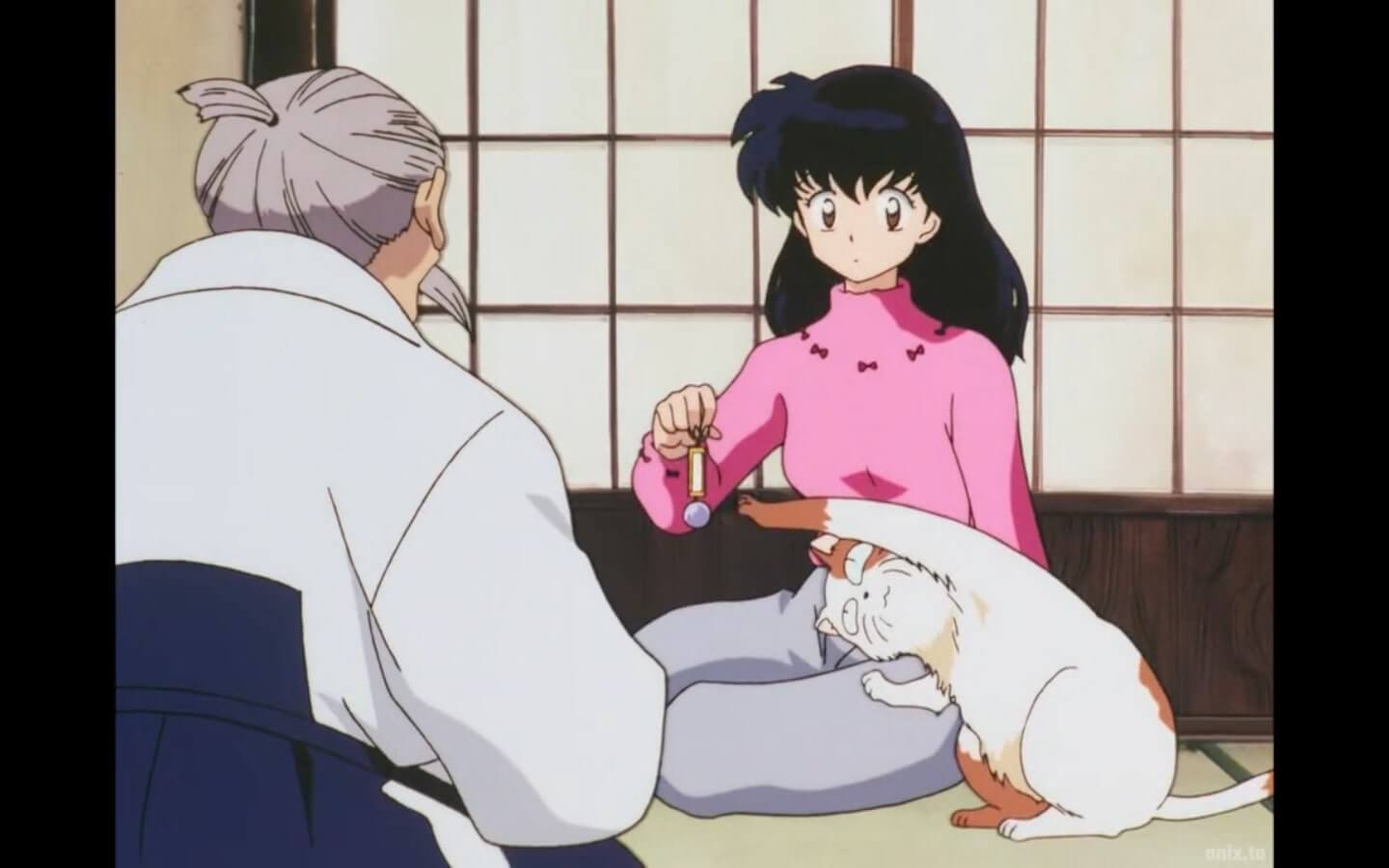 Kagome dangling the sacred jewel while a kitty reaches for it from her lap.