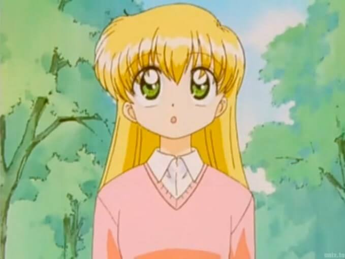 Miyu looking upwards. She has blonde hair, is wearing a pink sweater, and has huge green anime eyes.